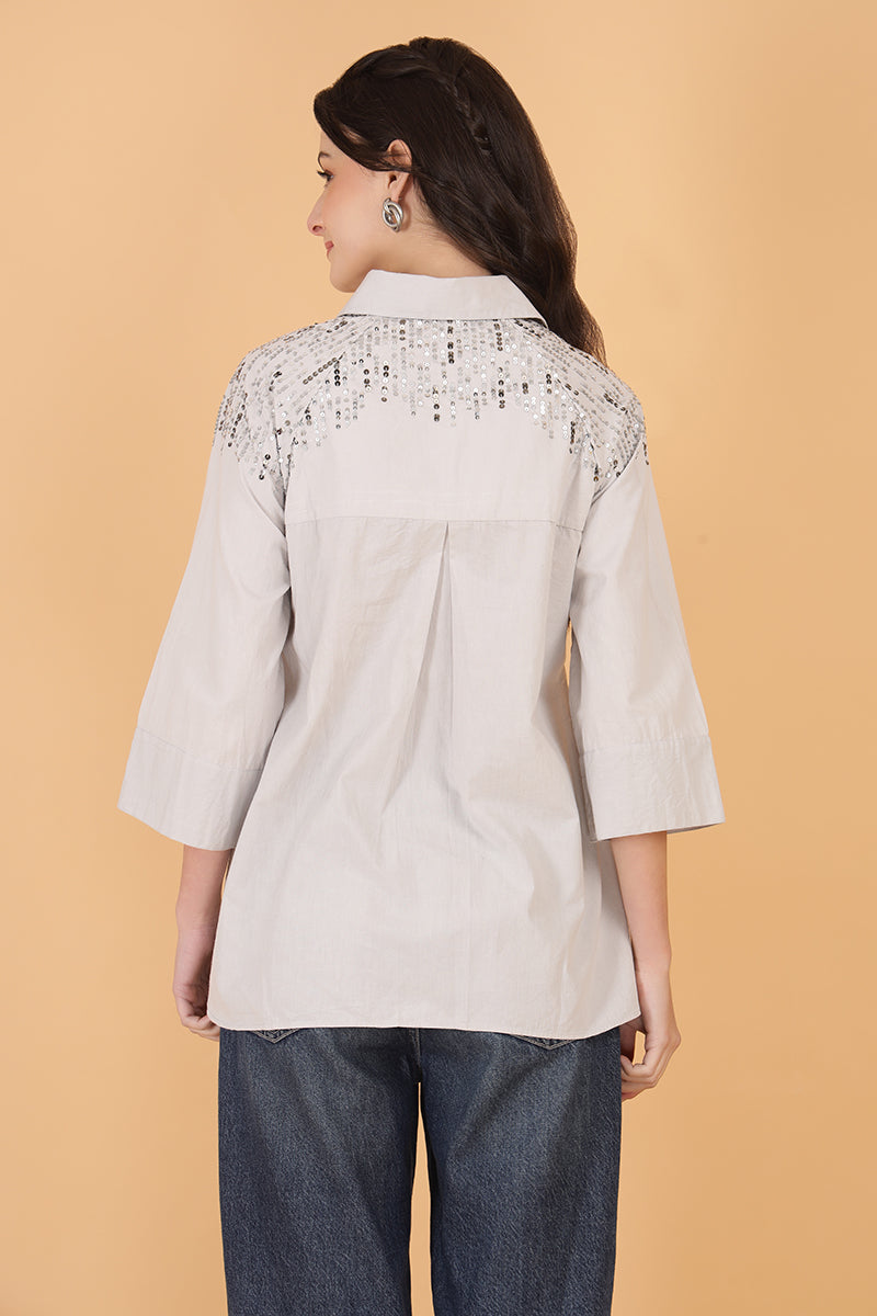 Trendy women’s embellished top with sparkle design, styled with denim pants