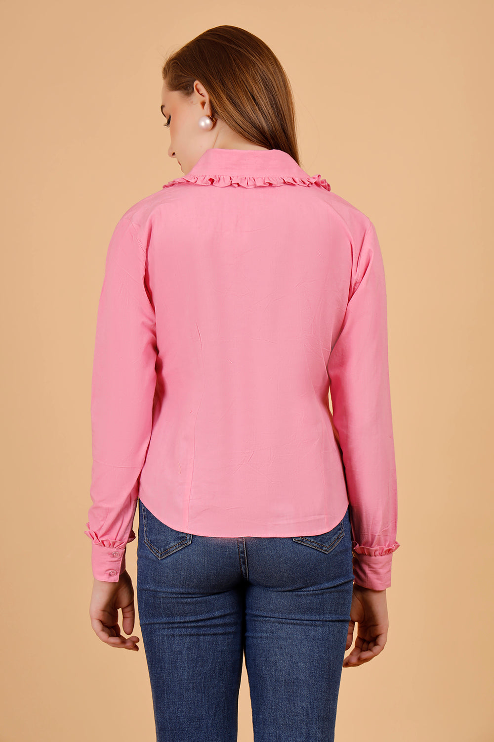 The women is wearing a cotton shirt in a beautiful candy pink colour, a full sleeved cotton top paired with jeans