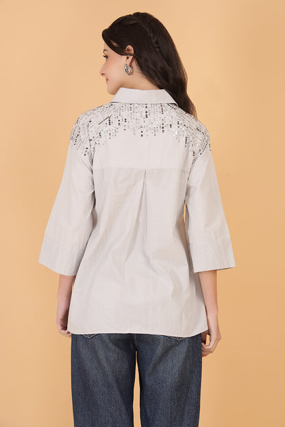 Trendy women’s embellished top with sparkle design, styled with denim pants