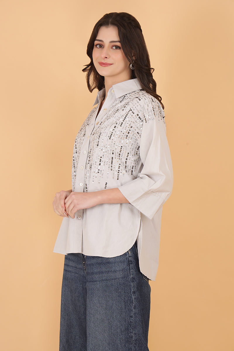 Embellished women's shirt with sequins and 3/4 sleeves paired with wide-leg jeans