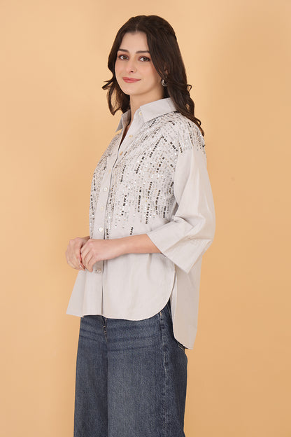 Embellished women's shirt with sequins and 3/4 sleeves paired with wide-leg jeans