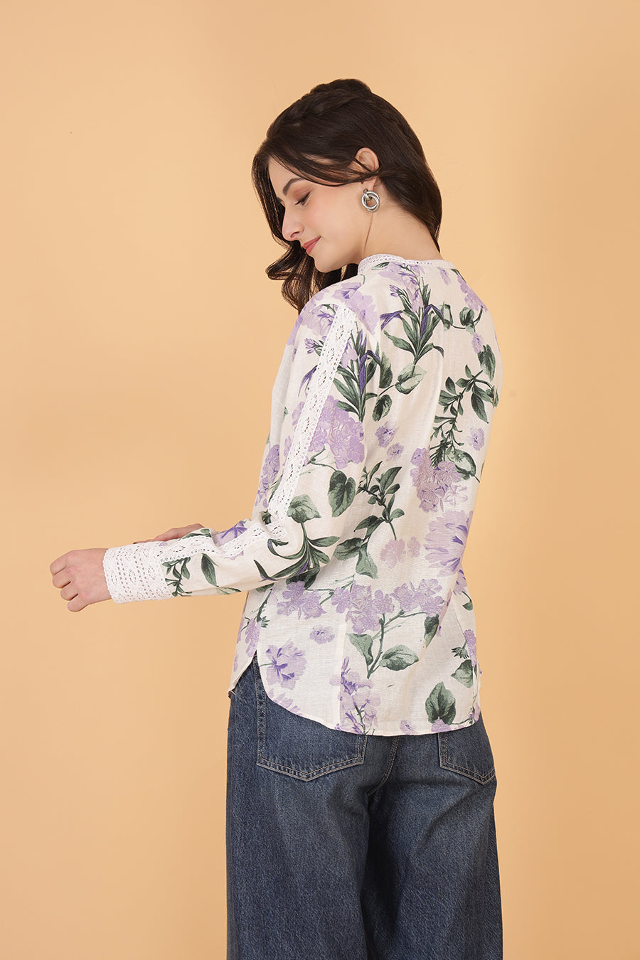Woman wearing a floral cotton blouse with a beige background