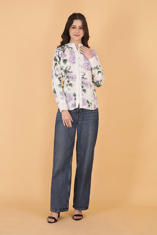 Woman wearing a floral blouse and jeans on a beige background