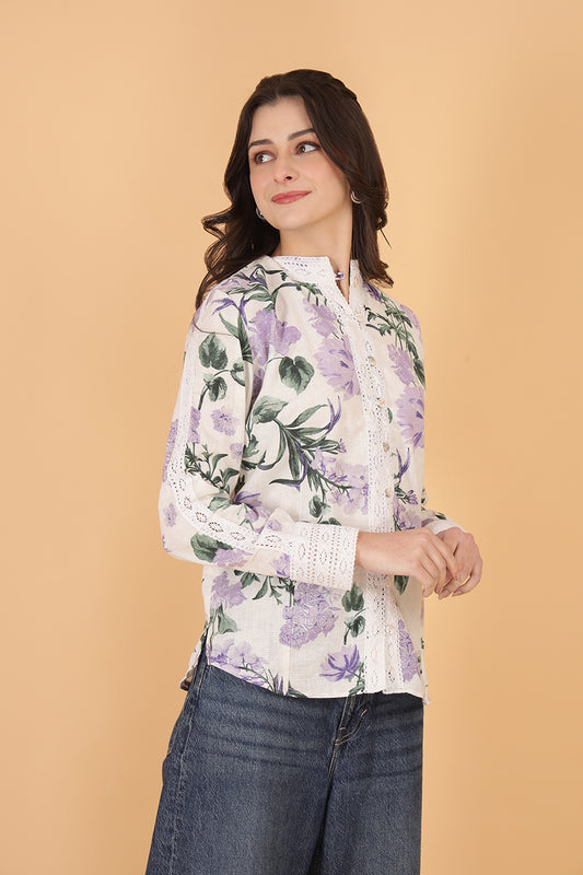 Woman wearing a floral linen  blouse with a beige background