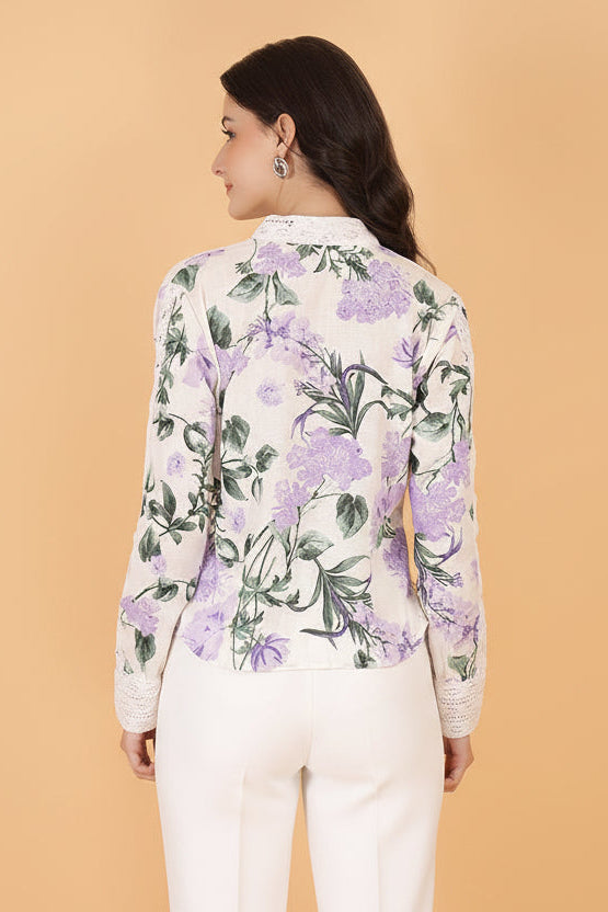 Woman wearing a floral shirt and white shorts against a beige background