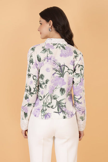 Woman wearing a floral shirt and white shorts against a beige background